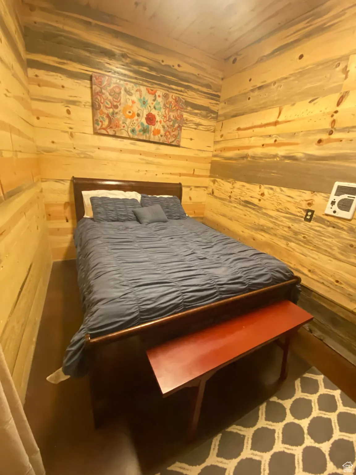 Bedroom featuring wooden walls and wood ceiling