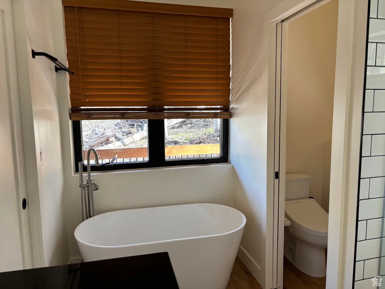Bathroom with a soaking tub and toilet
