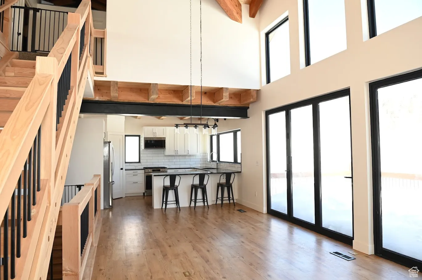 Kitchen with stainless steel appliances, a kitchen breakfast bar, a peninsula, a high ceiling, and backsplash
