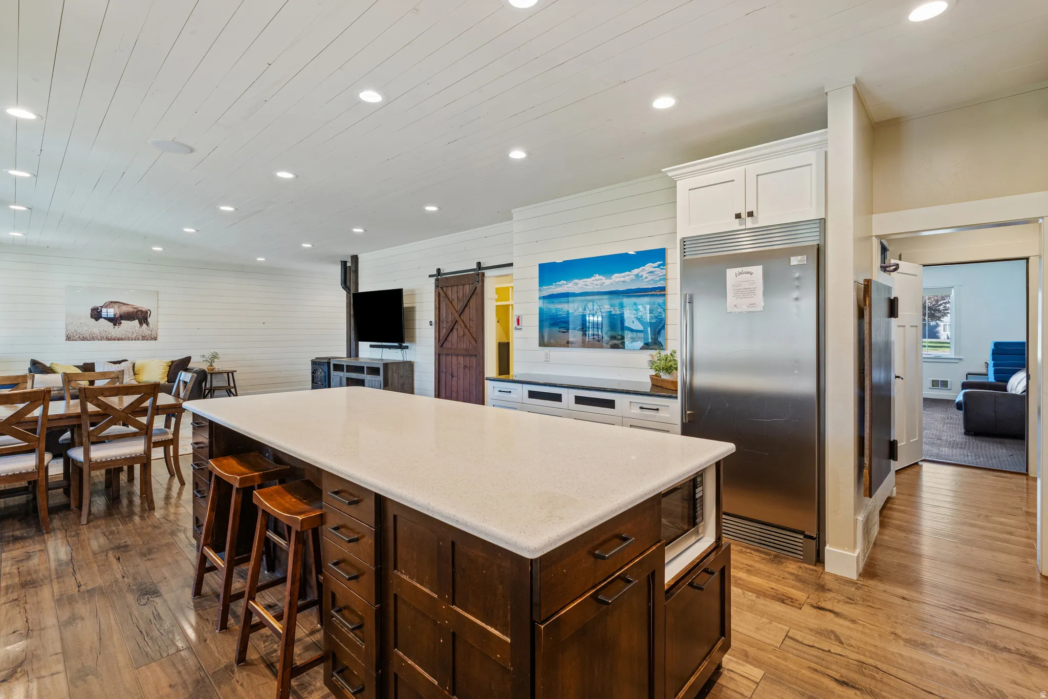 Spacious kitchen island with a light-colored countertop, integrated microwave, and dark wood cabinetry