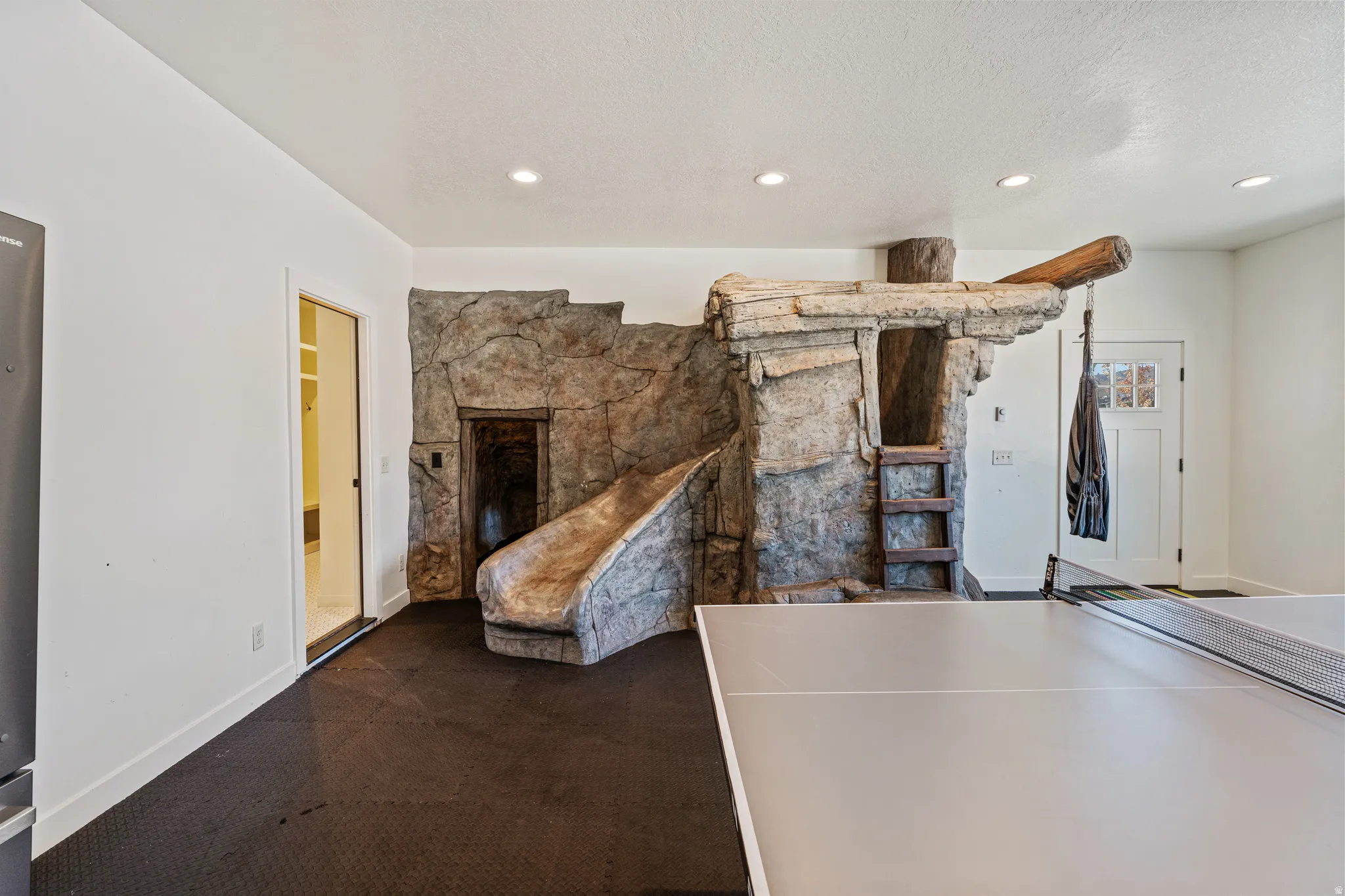 Custom stone-look play structure with integrated slide and ladder