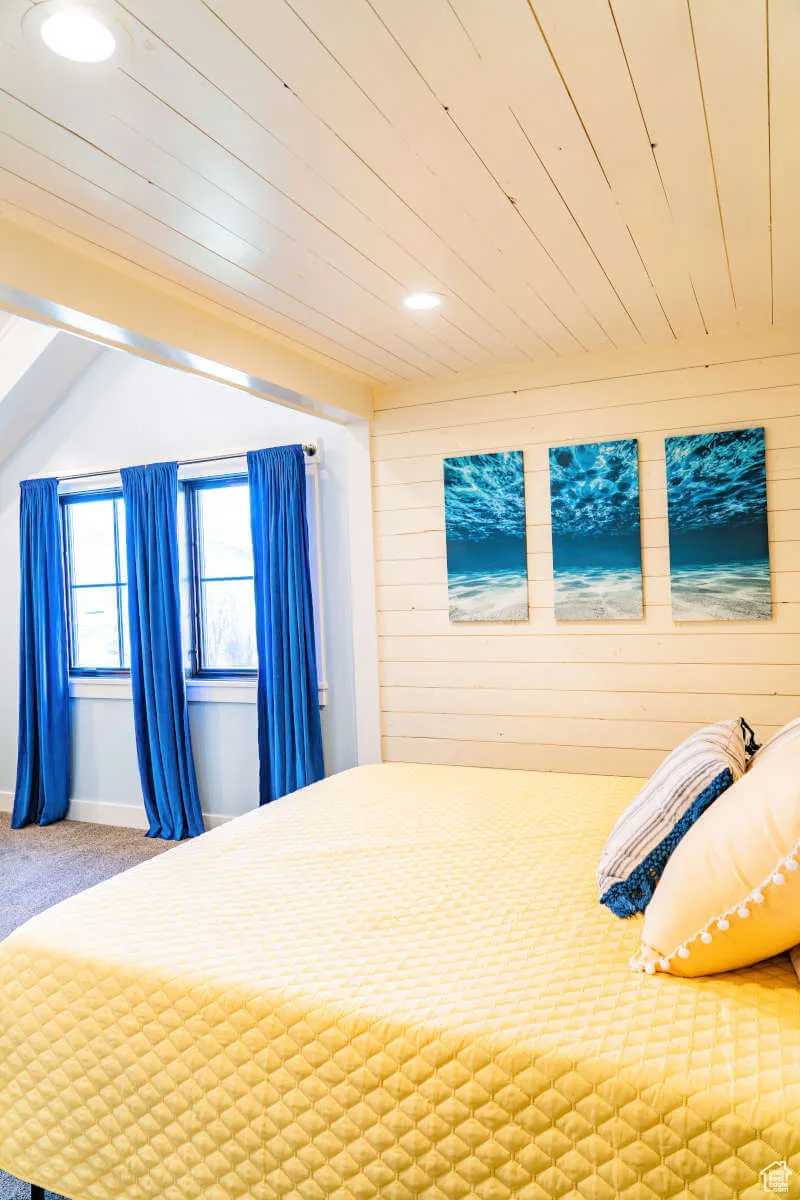 Unfurnished bedroom featuring recessed lighting, wooden walls, carpet, and wooden ceiling