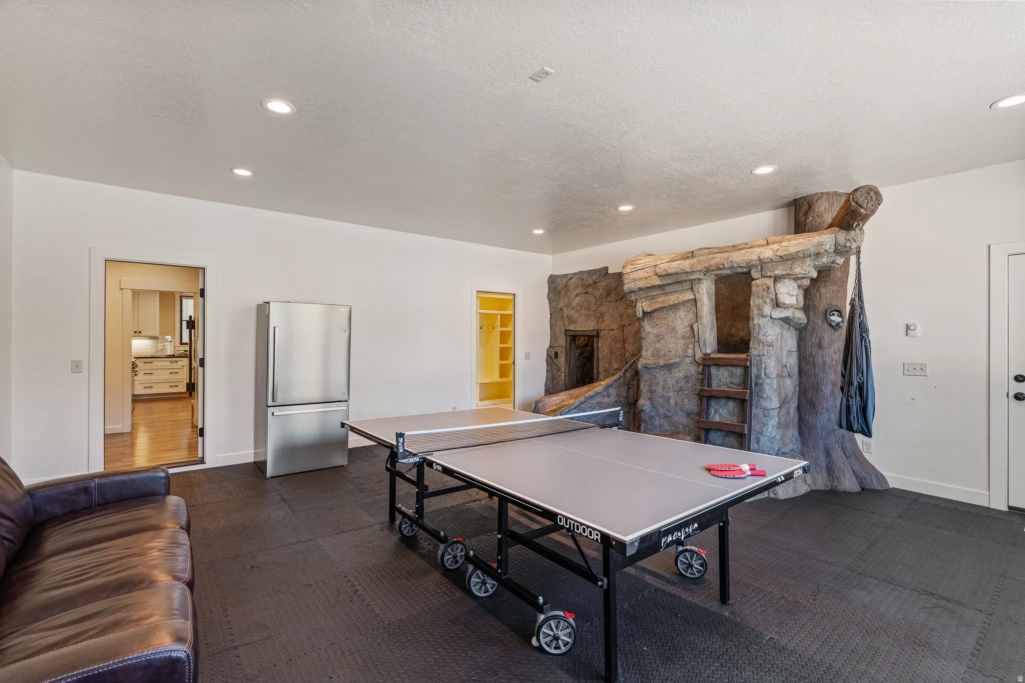 Spacious entertainment area featuring recessed lighting and a built-in play structure