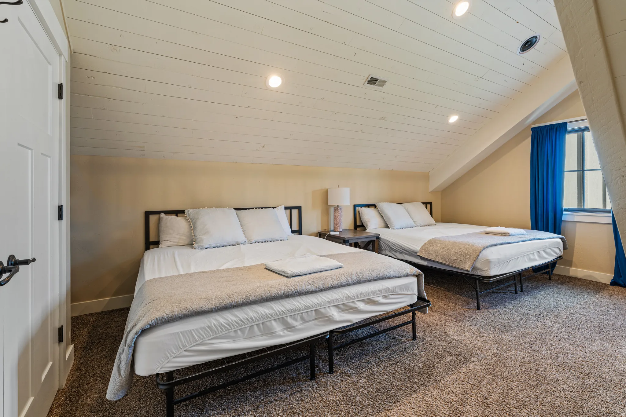 Sloped ceiling with wood paneling, recessed lighting, and soft carpet flooring