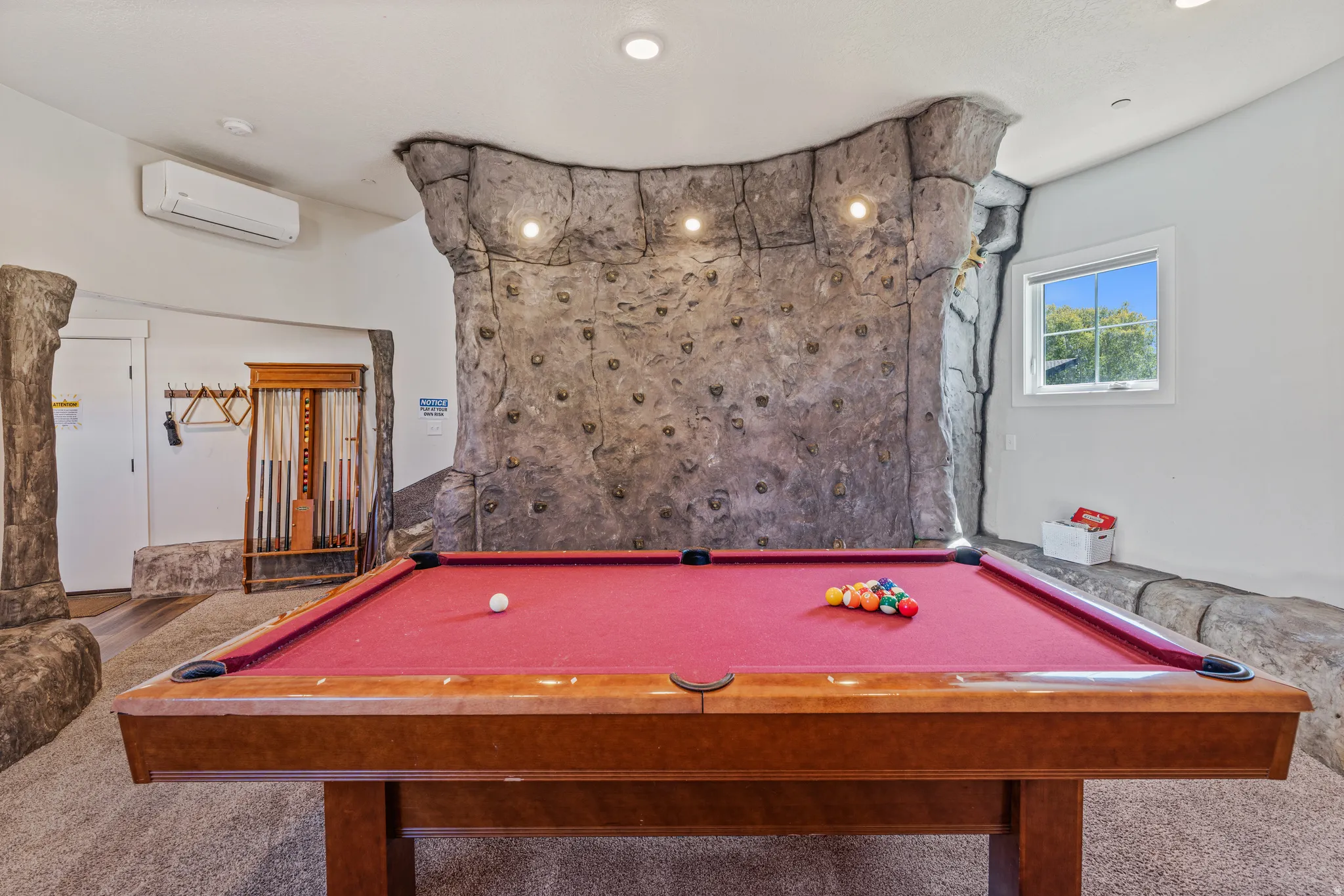 Interior space featuring an integrated climbing wall, recessed ceiling lighting, and a window with natural light