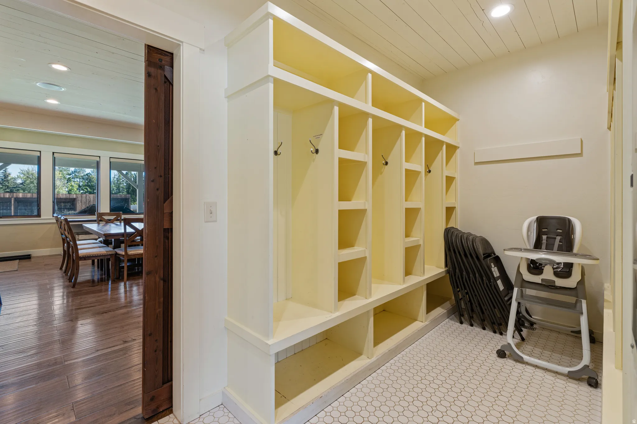Built-in storage cubbies with coat hooks, recessed lighting, hex tile flooring, and wood-finish flooring
