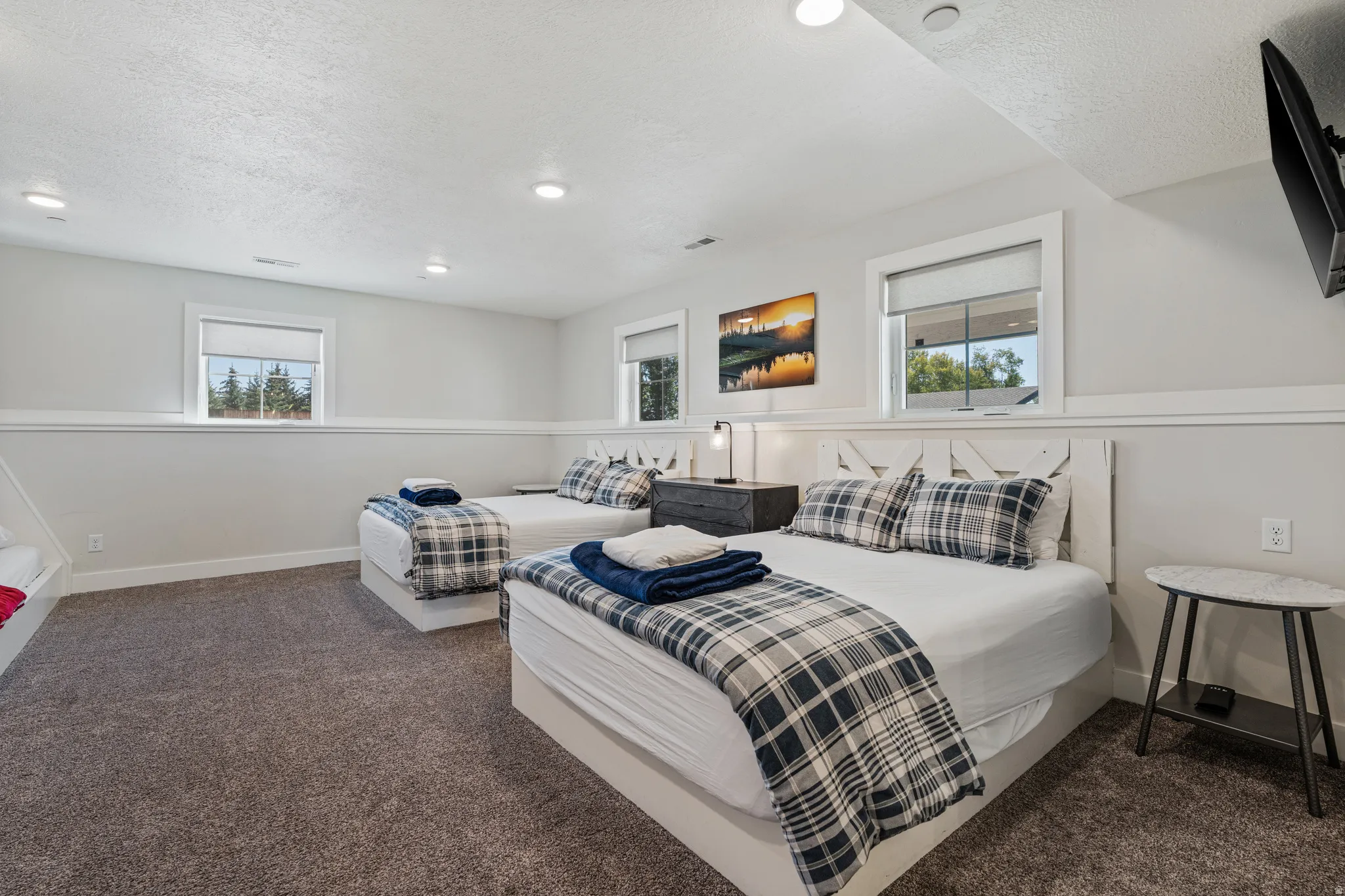 Recessed lighting, light gray wall color, white trim, wood-finish headboard, and carpeted flooring