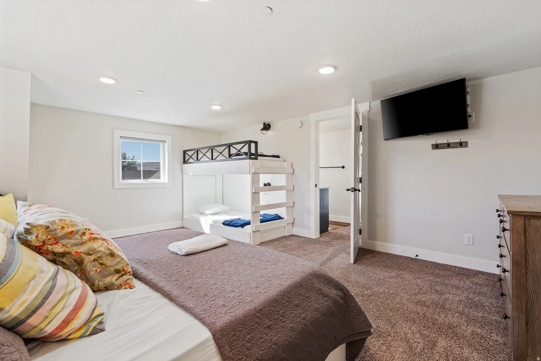 Bedroom featuring a window, built-in bunk beds, recessed lighting, and a wall-mounted television