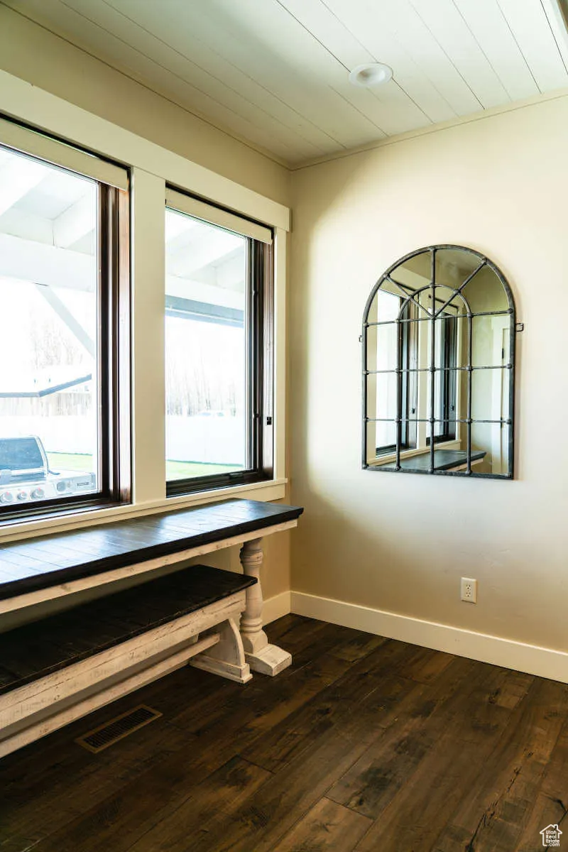 Unfurnished room with baseboards and dark wood-style flooring