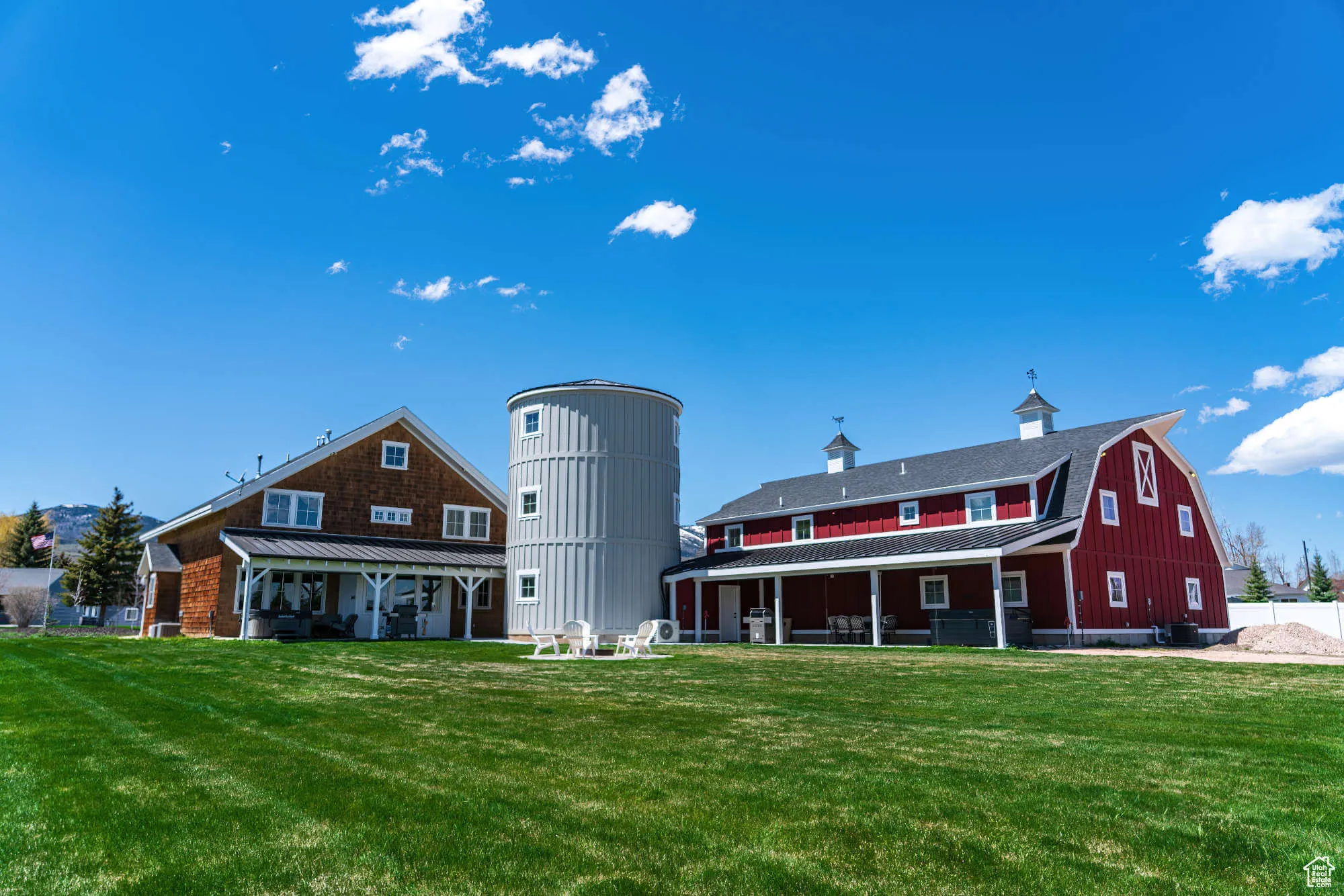 Back of property with a barn, a lawn, and metal roof