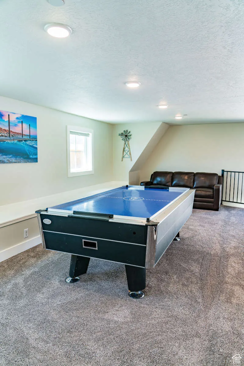 Rec room with carpet flooring, a textured ceiling, recessed lighting, and baseboards