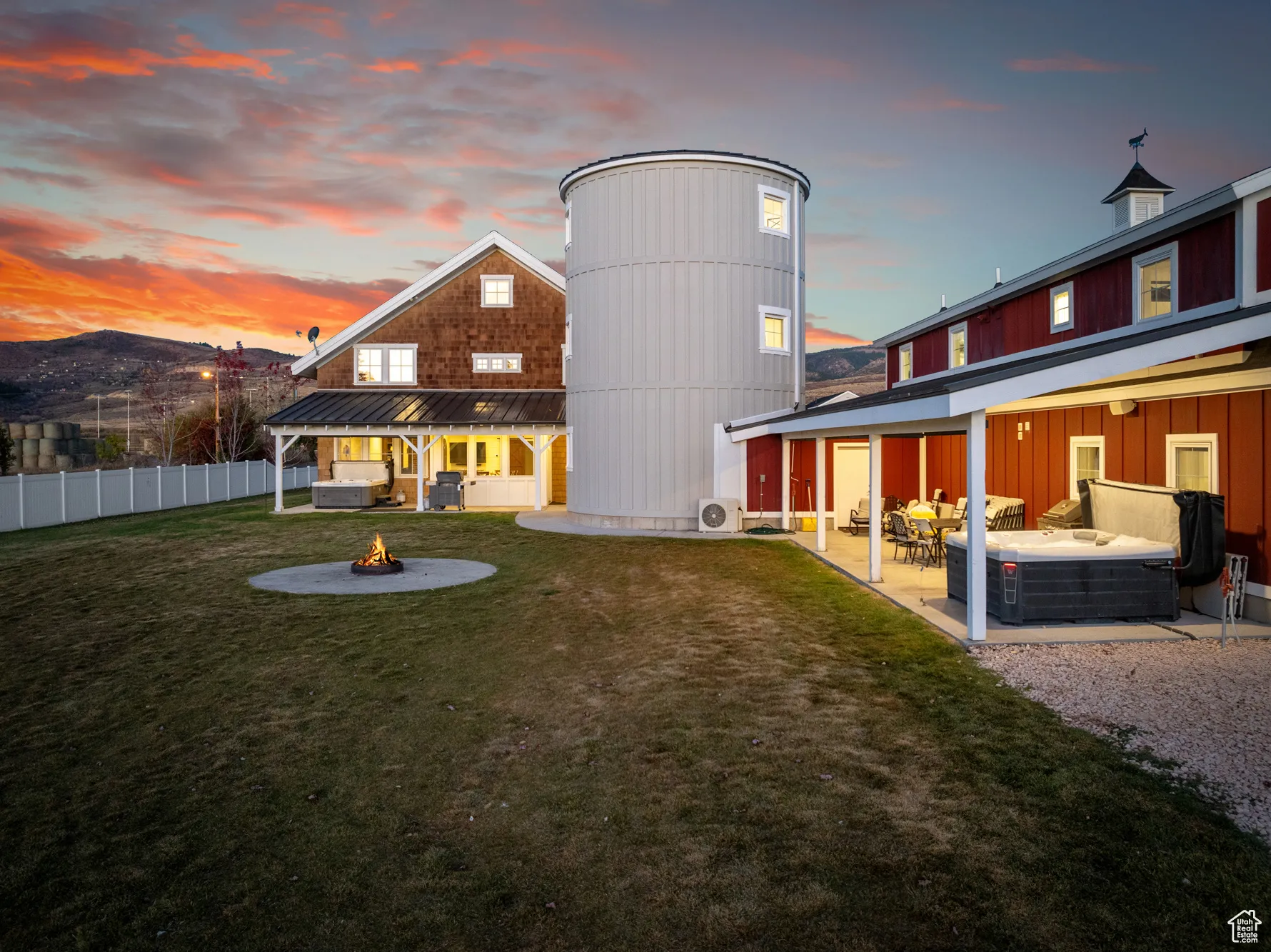 Back of property at dusk with an outdoor living space with a fire pit, a patio, metal roof, and a standing seam roof