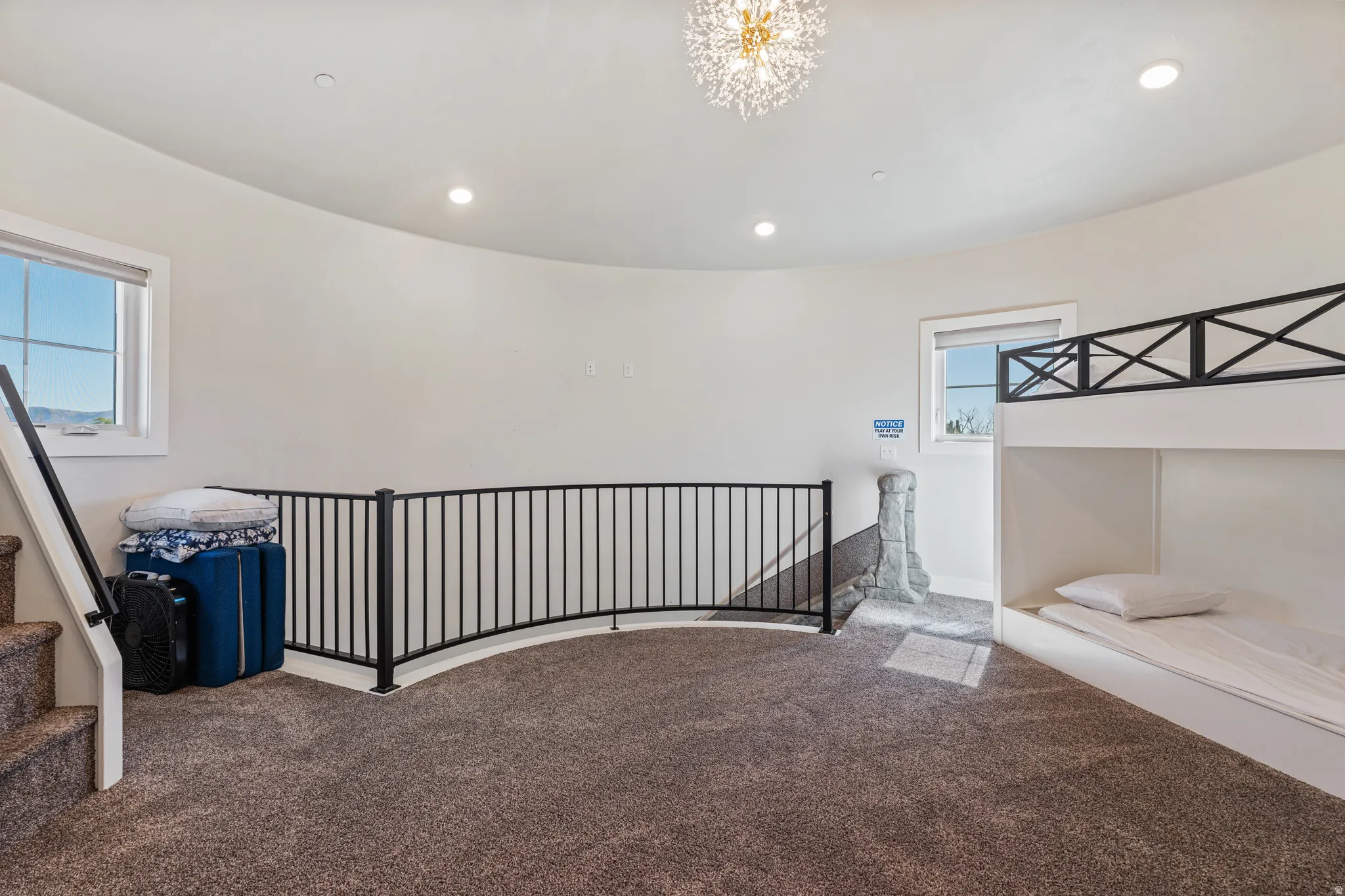 Curved wall design, recessed lighting, chandelier, built-in bunk beds, and dark metal railing