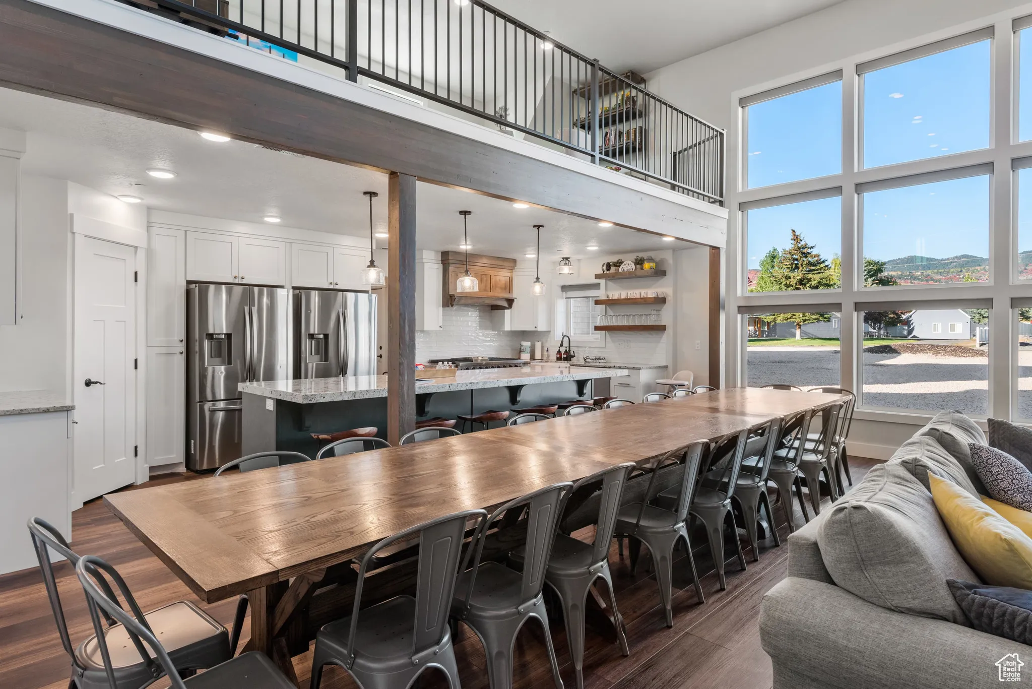 Dining room with dark wood finished floors, a towering ceiling, and recessed lighting