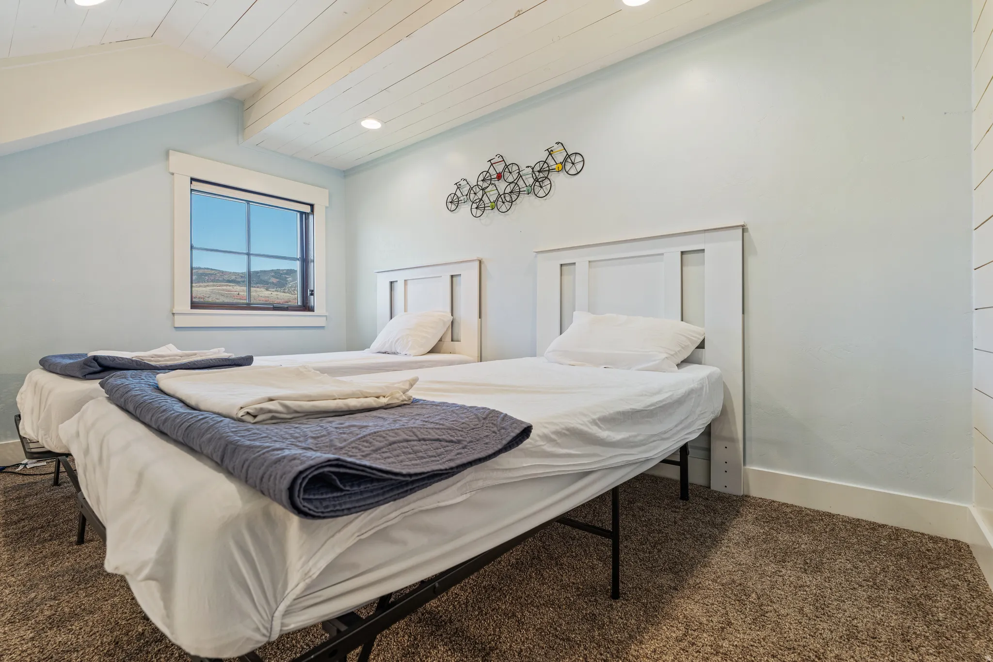 Window offering distant scenery, light blue wall paint, recessed lighting, wood-paneled ceiling, and carpeted flooring