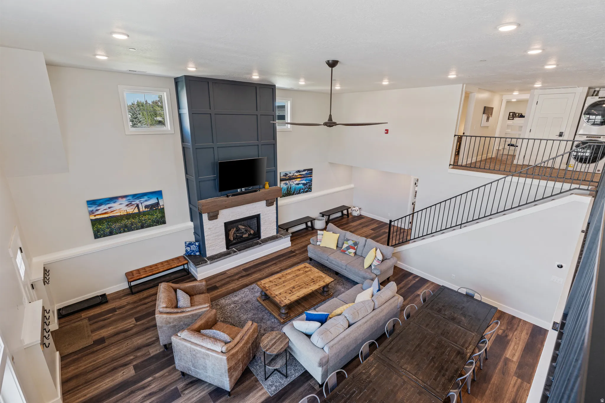 Great room featuring a floor-to-ceiling accent wall with wainscoting detail and a fireplace with a white brick surround
