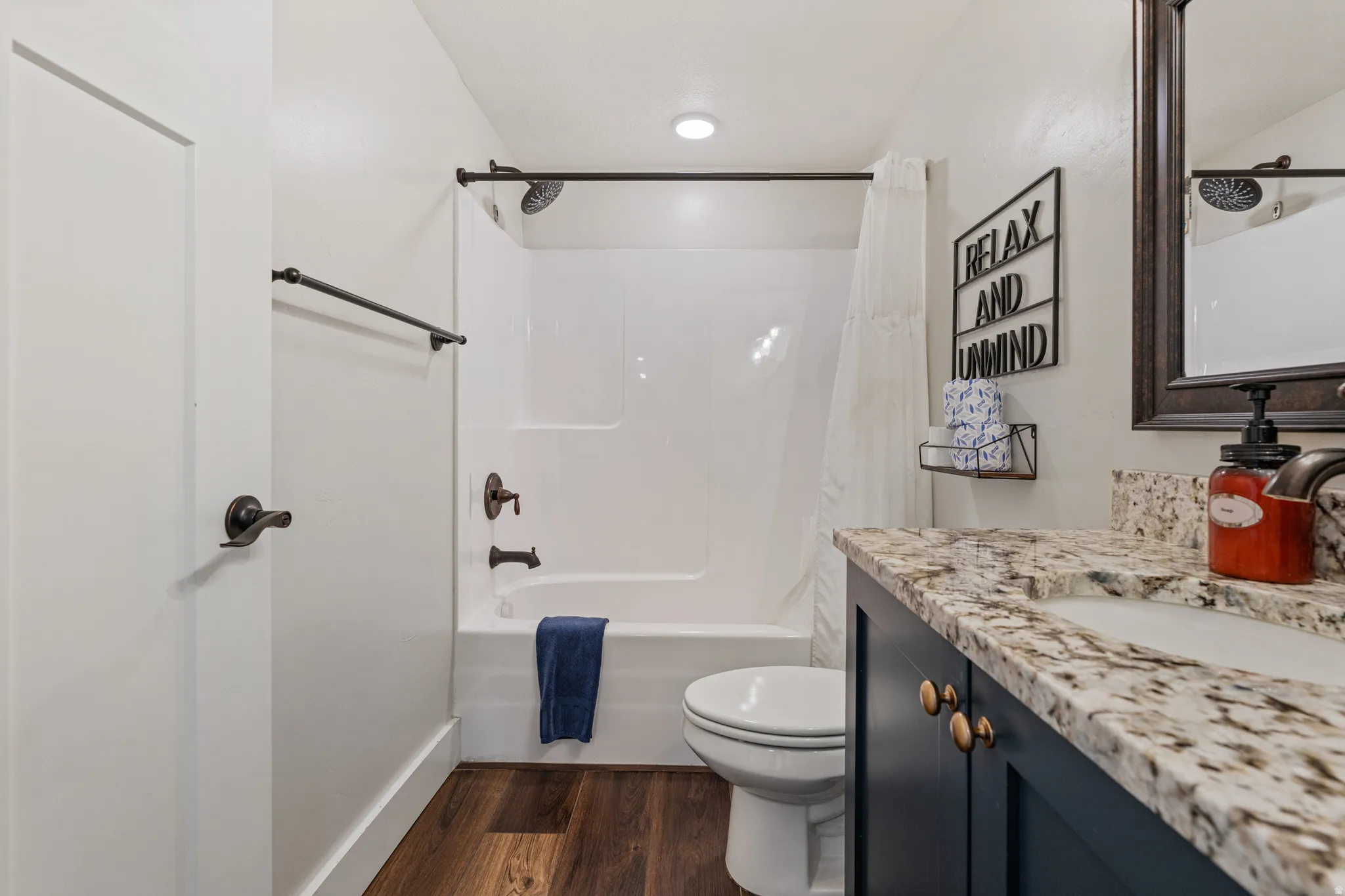 White bathtub with an integrated shower, complemented by dark bronze fixtures