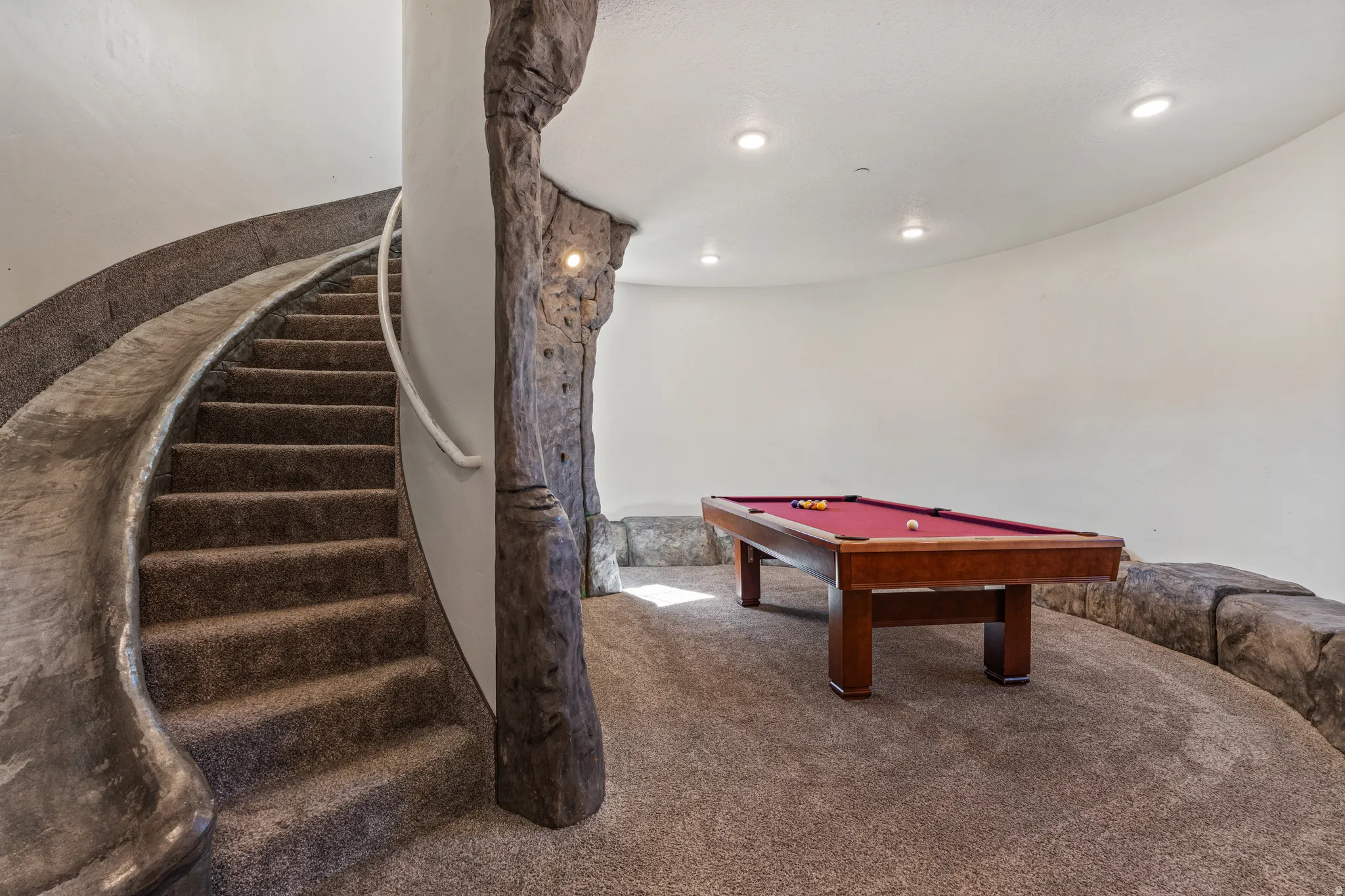 Curved staircase with textured rock-like detailing
