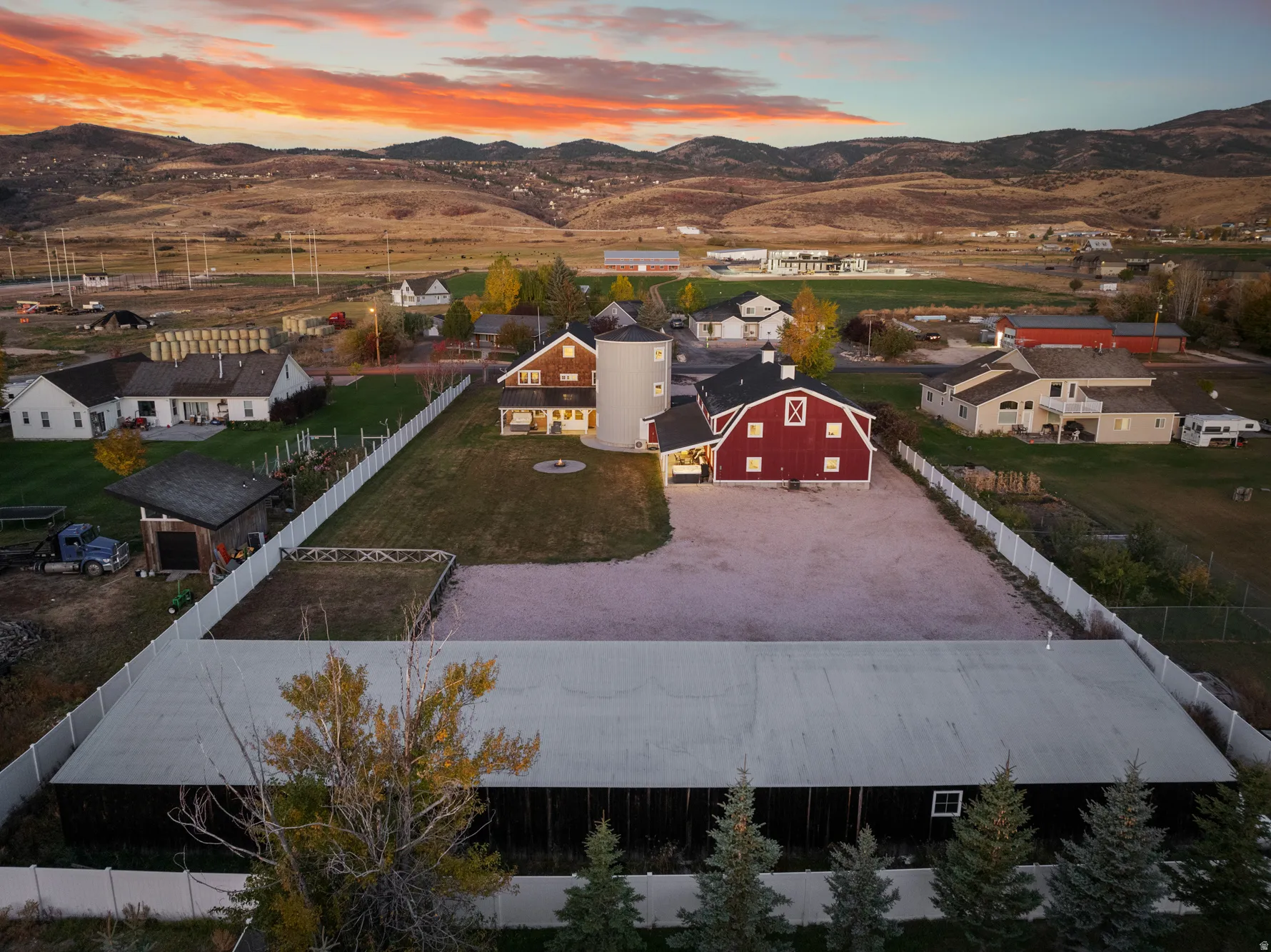 Expansive property featuring a red barn, a silo, and multiple outbuildings