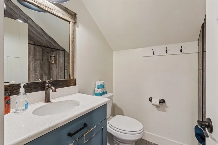 Vanity with integrated sink, bronze-finish faucet, and distressed wood-frame mirror