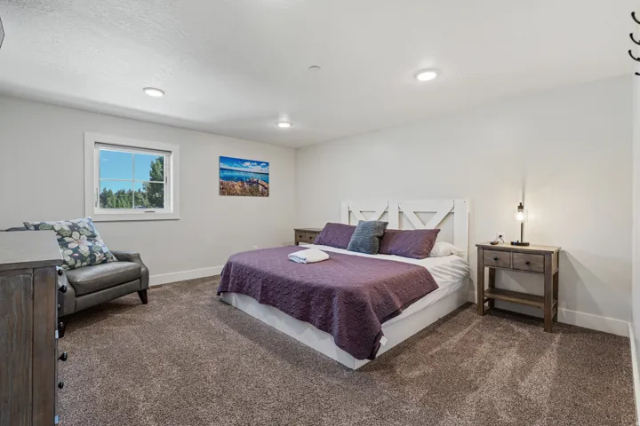 Recessed lighting, window with white trim, light-toned wall paint, and textured carpeting