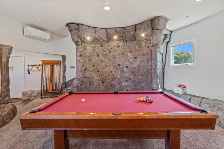 Interior space featuring an integrated climbing wall, recessed ceiling lighting, and a window with natural light