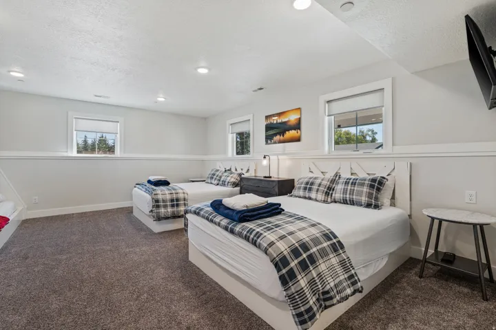 Recessed lighting, light gray wall color, white trim, wood-finish headboard, and carpeted flooring
