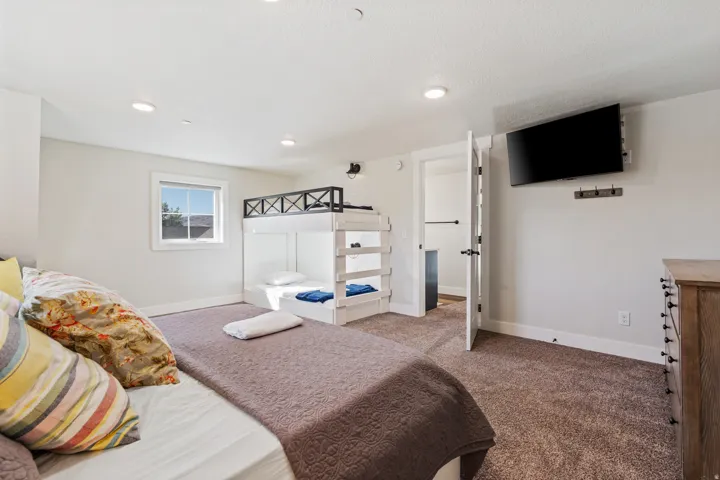Bedroom featuring a window, built-in bunk beds, recessed lighting, and a wall-mounted television