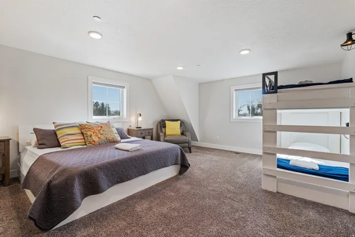 Spacious room featuring plush carpet, recessed lighting, white trim windows, and an accent wall