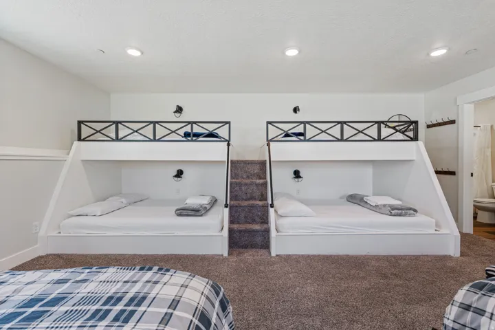 Built-in bunk beds with integrated steps, individual wall sconces, and recessed lighting