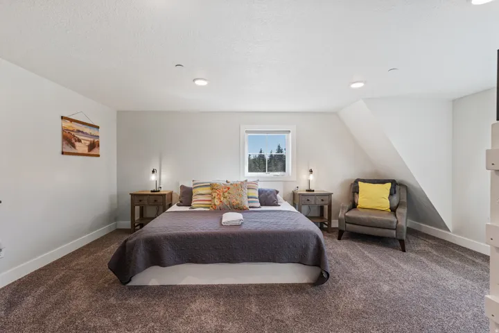 Recessed lighting, window with exterior scenery, wall-to-wall carpeting, and sloped ceiling detail