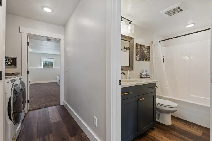 Hallway featuring wood-finish flooring, recessed lighting, and a built-in laundry area