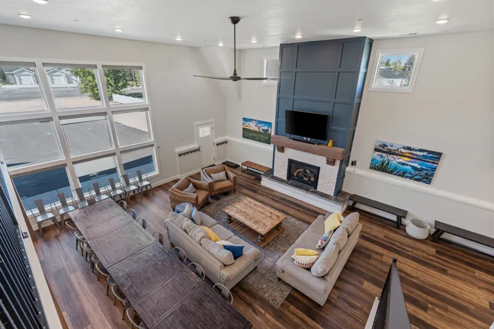 Vaulted ceilings, extensive wood-finish flooring, and a stone-surround fireplace with a wood mantel