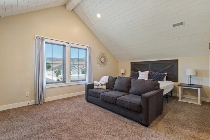 Vaulted ceiling with white wood-finish planks, recessed lighting, and warm beige wall tones