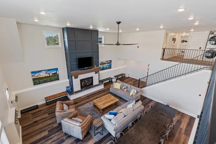 Great room featuring a floor-to-ceiling accent wall with wainscoting detail and a fireplace with a white brick surround