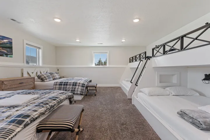 Recessed ceiling lighting, durable carpeting, multiple windows, and built-in bunk beds with integrated lighting