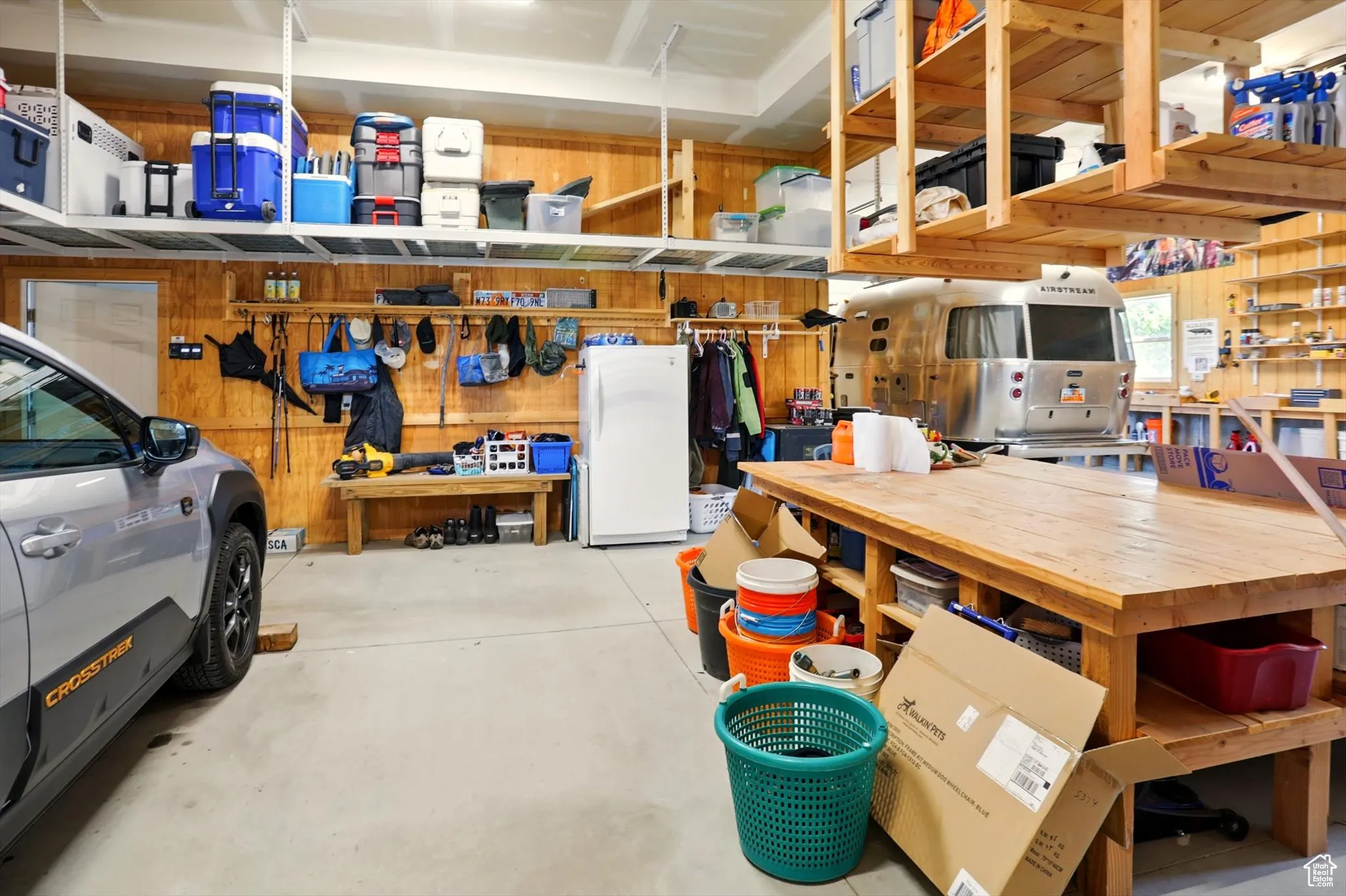 Garage with a workshop area and freestanding refrigerator
