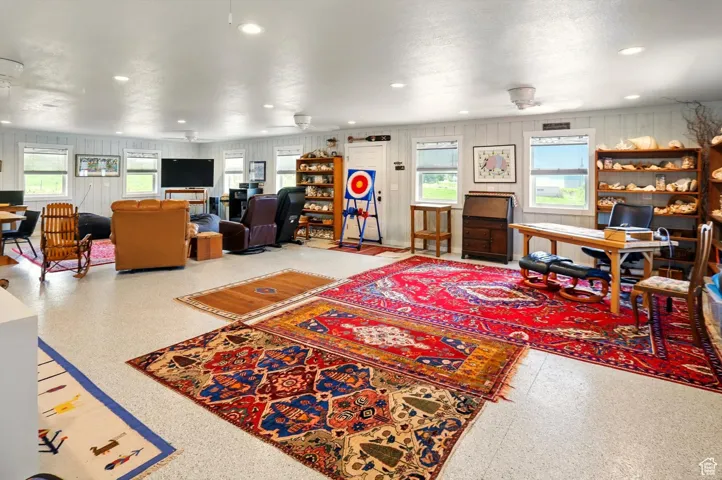 Living area featuring a desk, speckle patterned floor, a ceiling fan, and recessed lighting