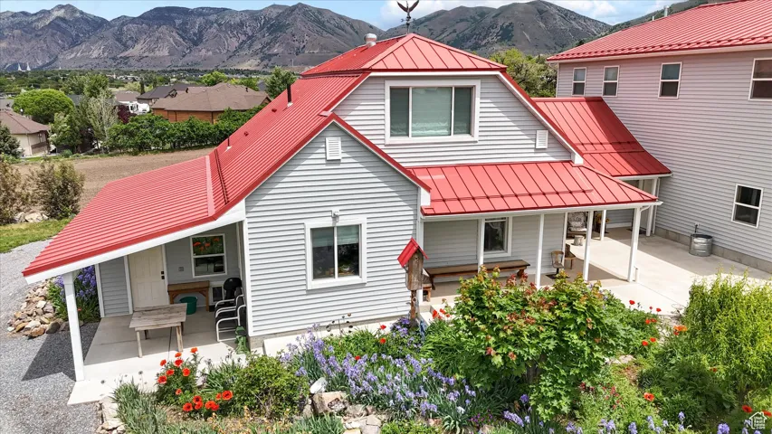 Back of property with a standing seam roof, a mountain view, and metal roof