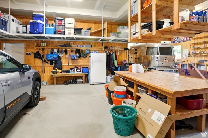 Garage with a workshop area and freestanding refrigerator