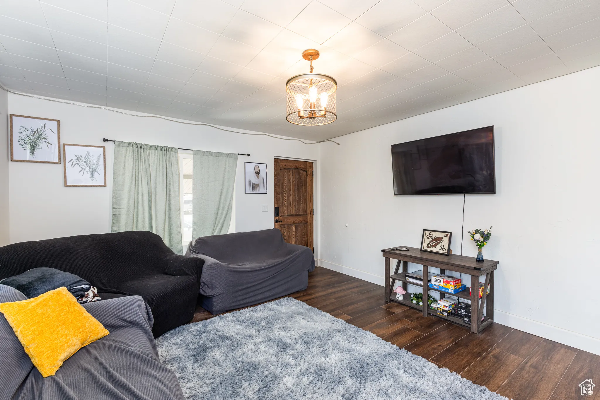 Living room with wood finished floors, baseboards, and a chandelier