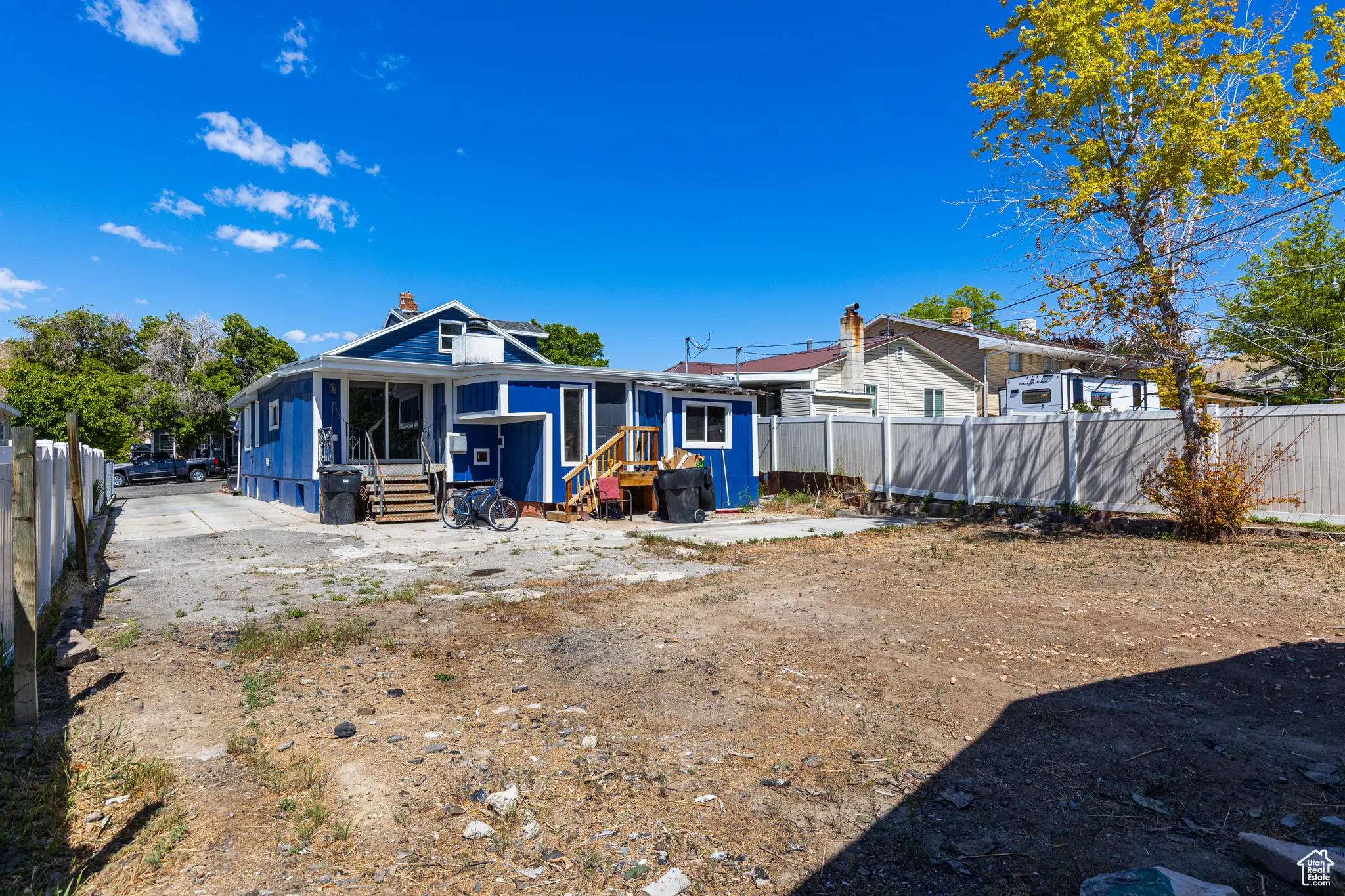 Rear view of property with a fenced backyard, entry steps, a chimney, and a sunroom
