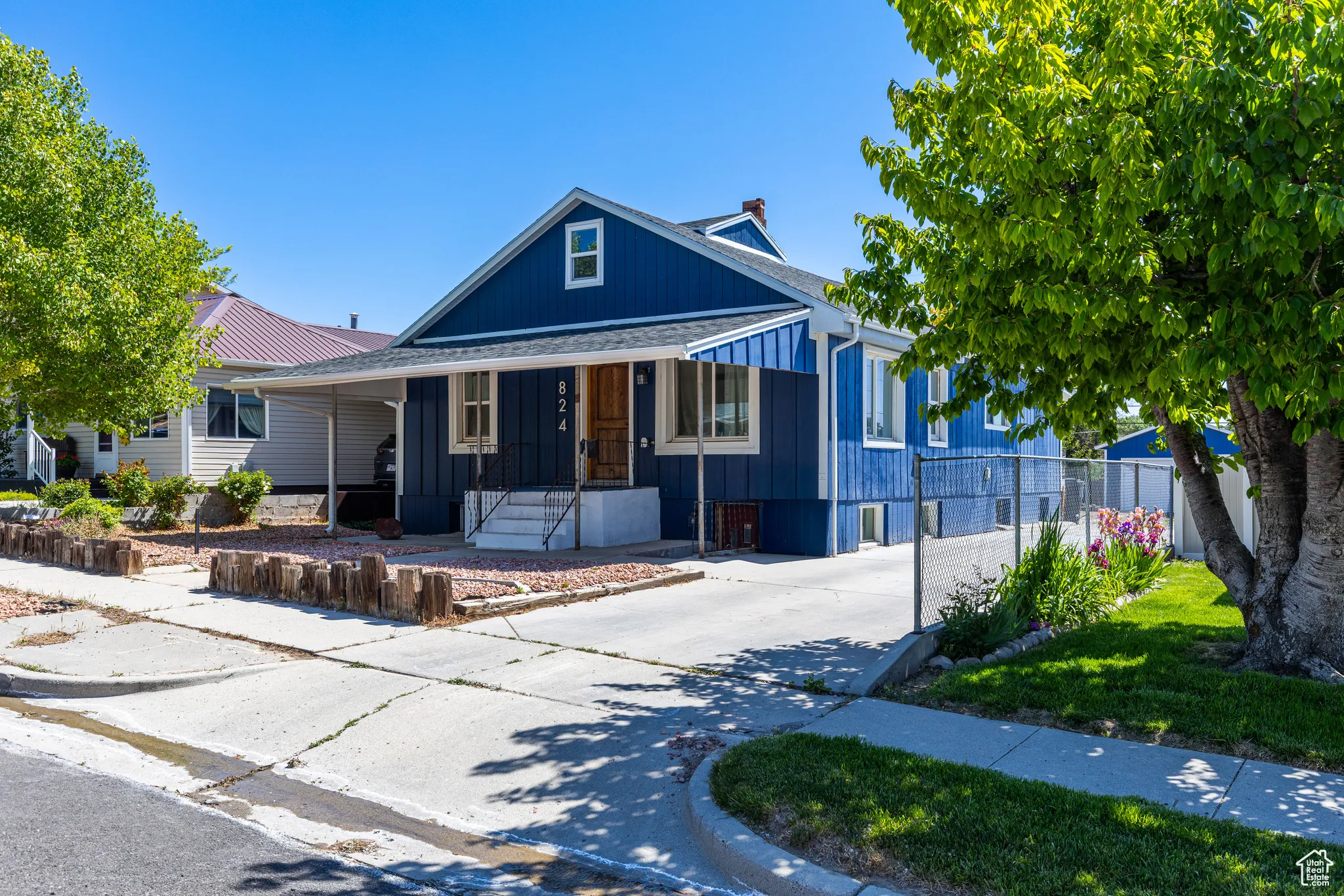 View of front facade featuring a porch, concrete driveway, a shingled roof, and board and batten siding