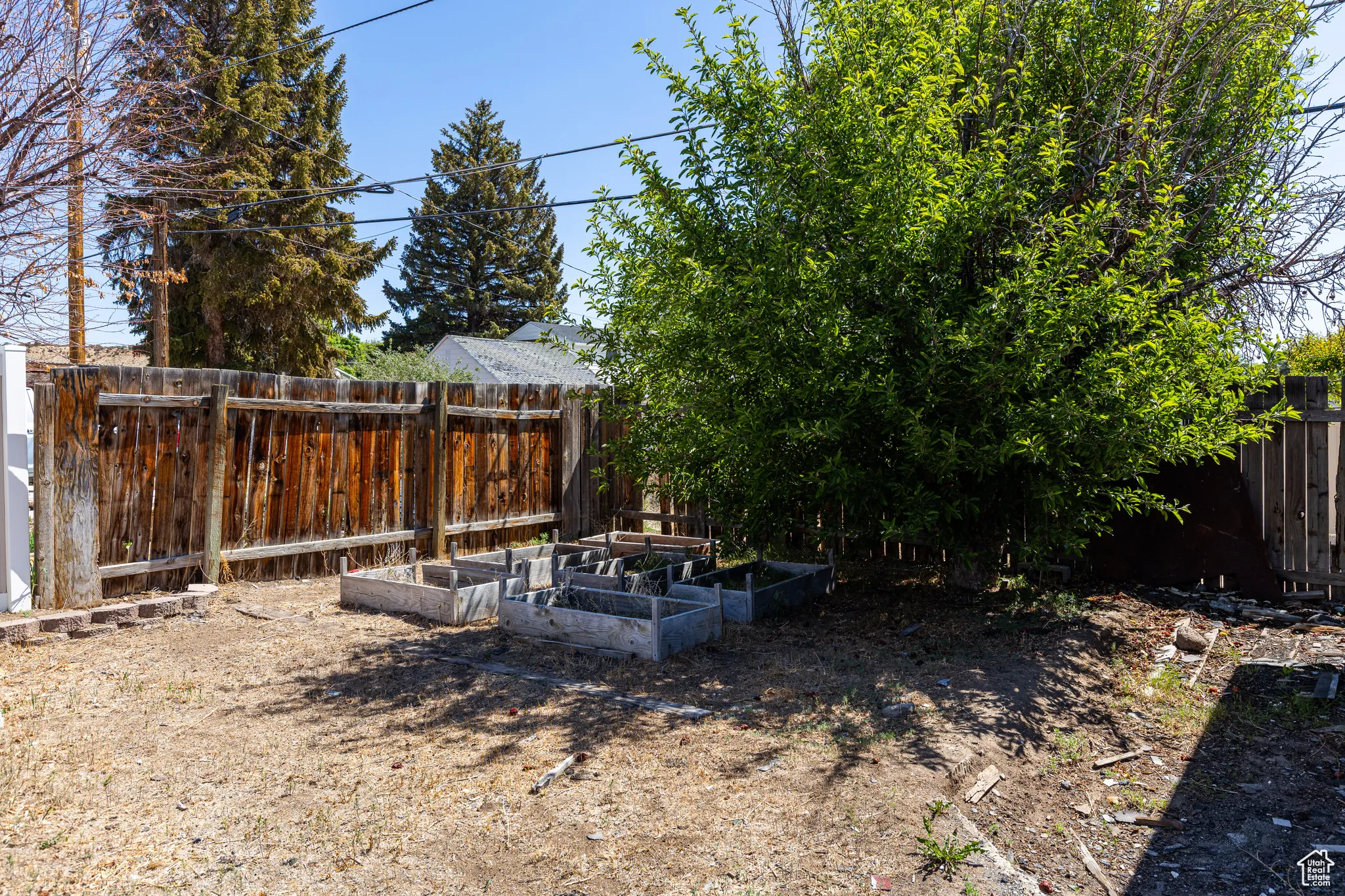 Fenced backyard featuring a garden
