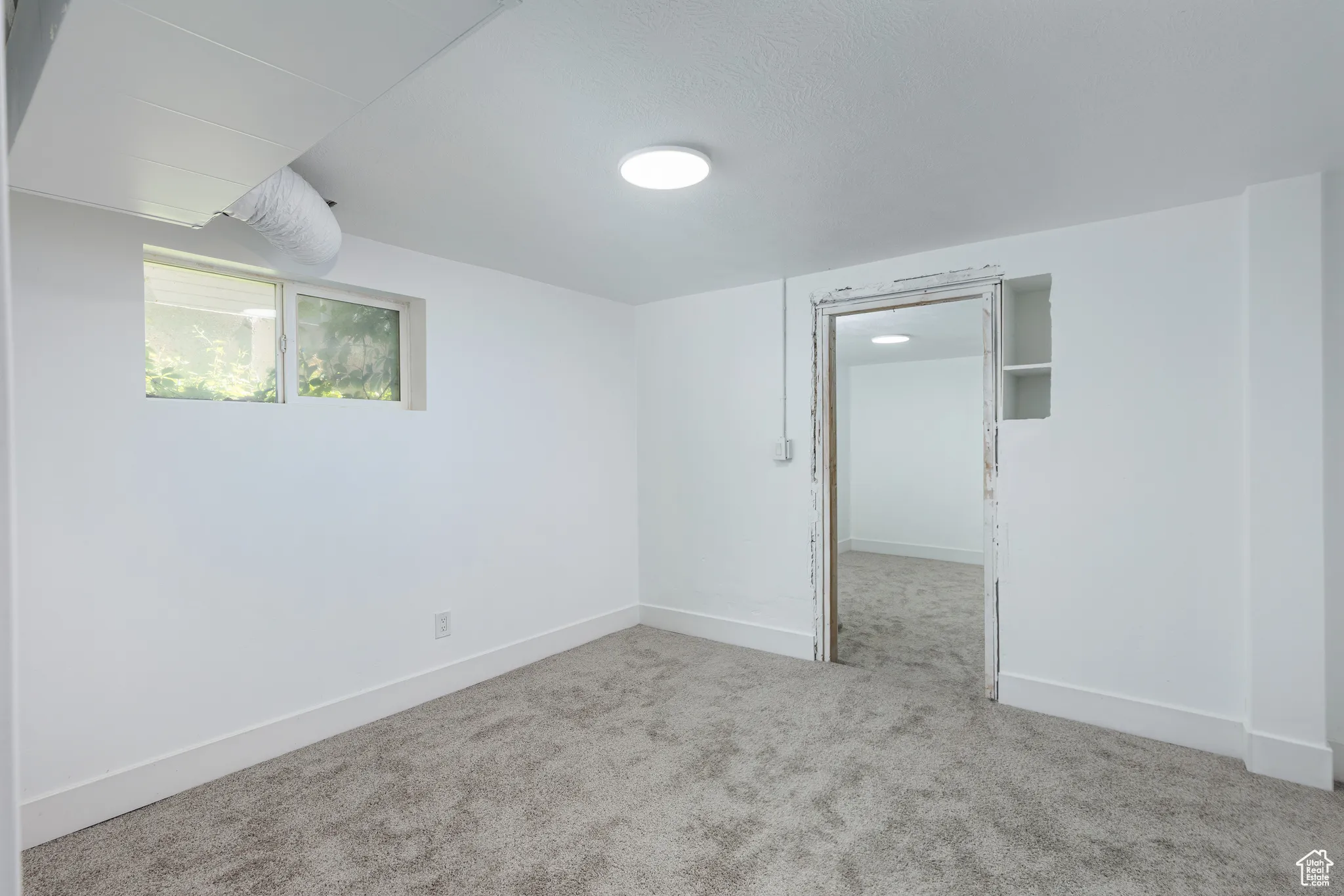 Carpeted spare room with baseboards