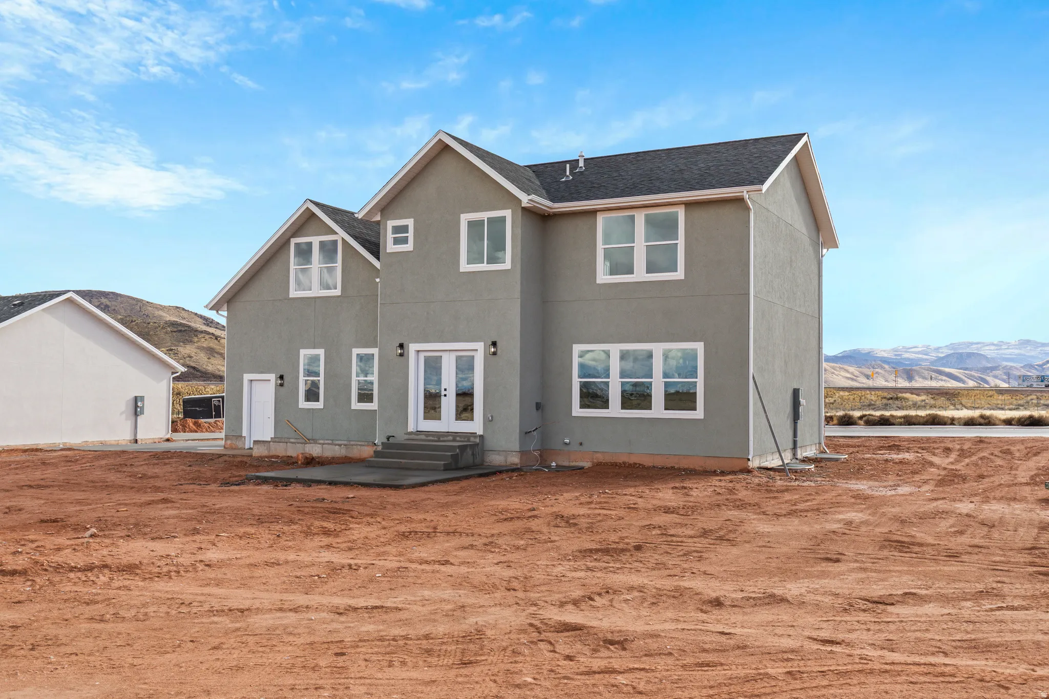 Back of house with french doors, stucco siding, and roof with shingles