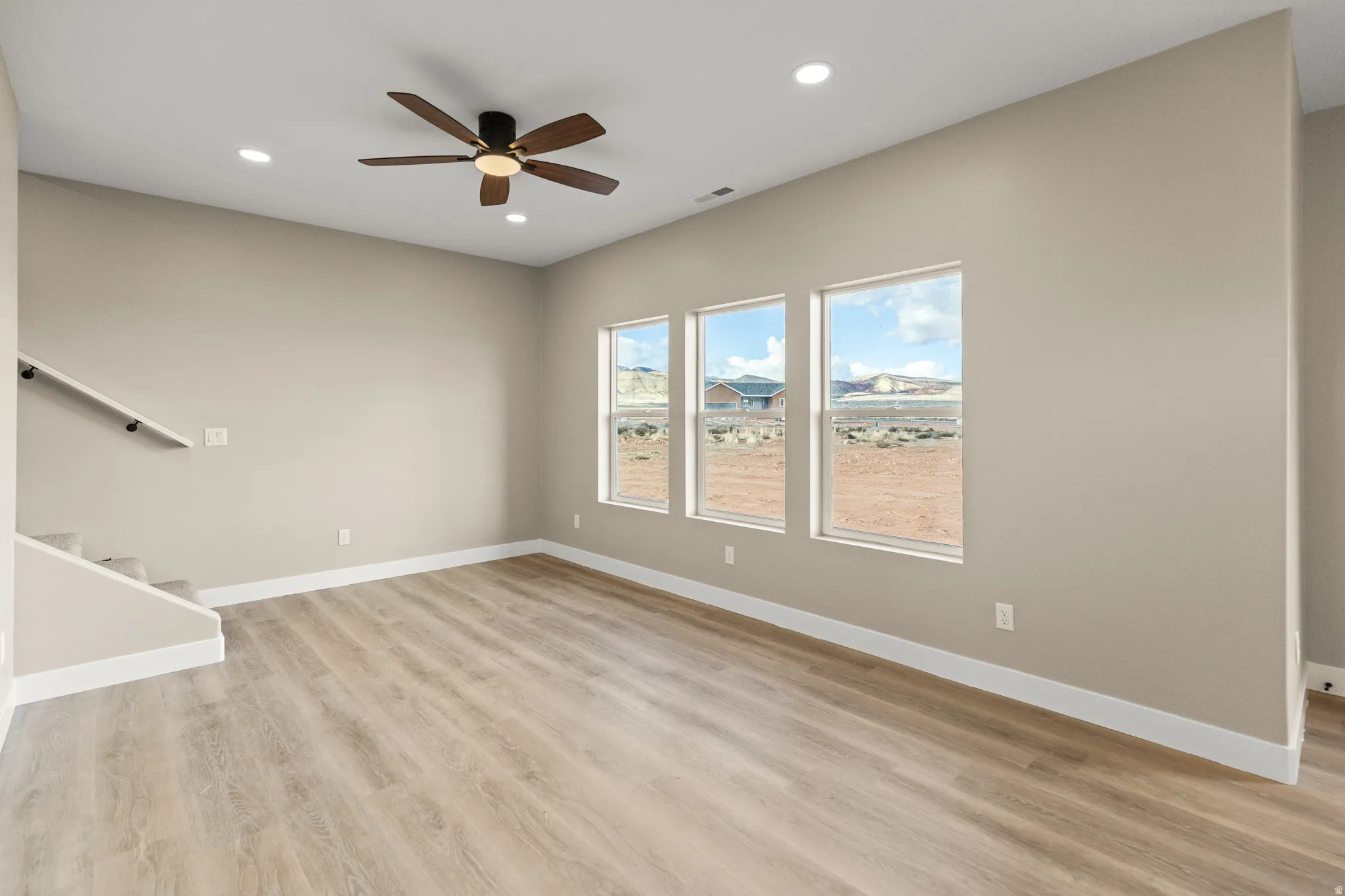 Unfurnished living room with stairs, light wood-type flooring, recessed lighting, and ceiling fan