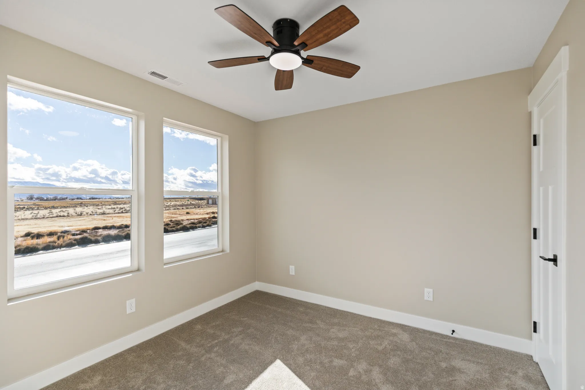 Spare room with carpet flooring and ceiling fan