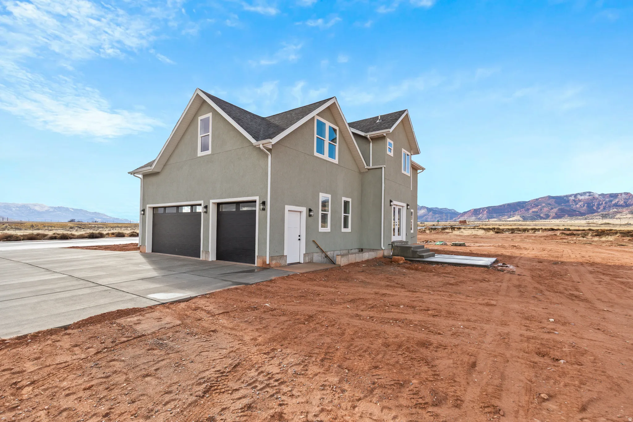 View of home's exterior featuring a mountain view, stucco siding, driveway, and an attached garage