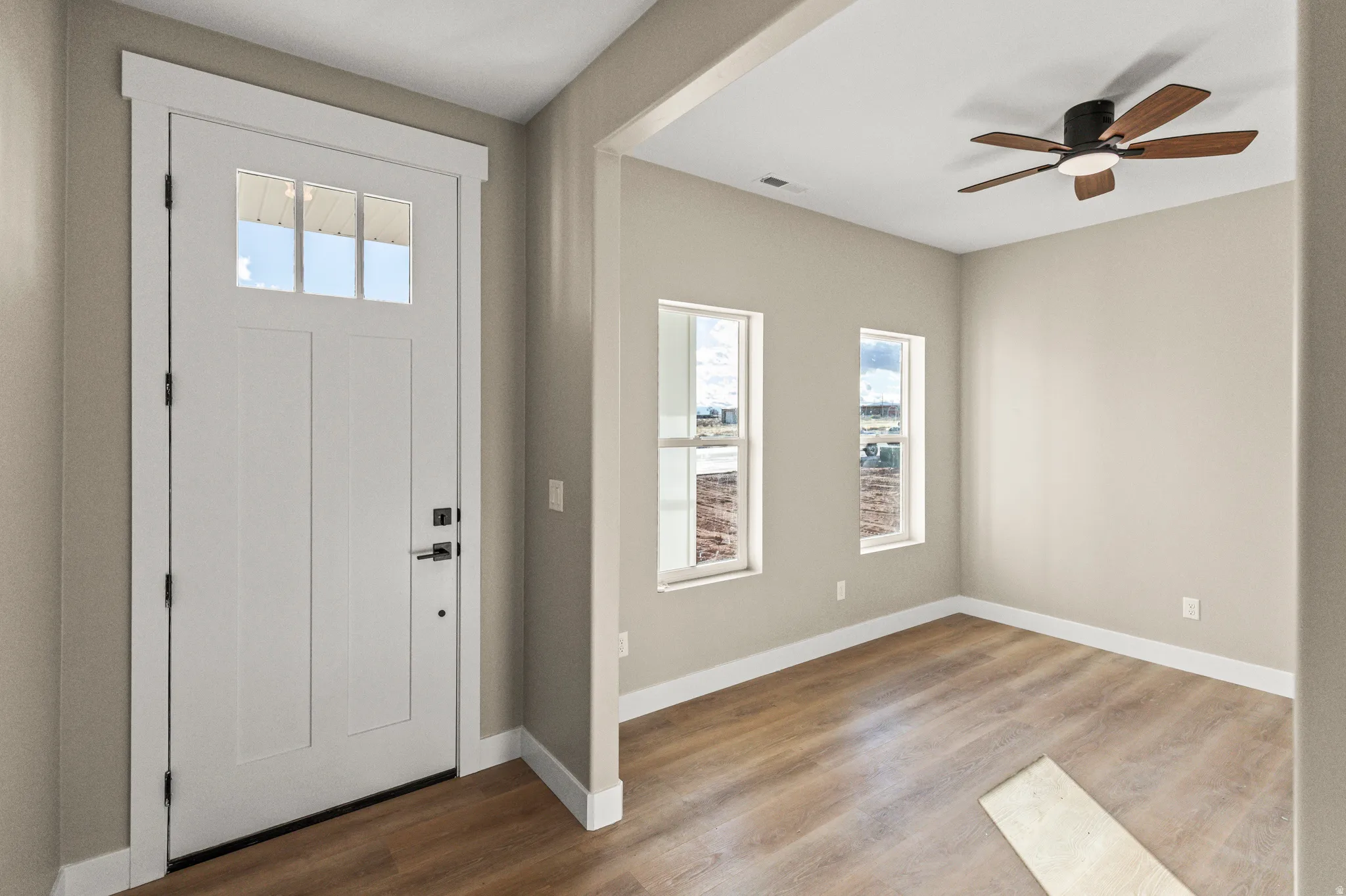 Entryway with plenty of natural light, wood finished floors, and ceiling fan